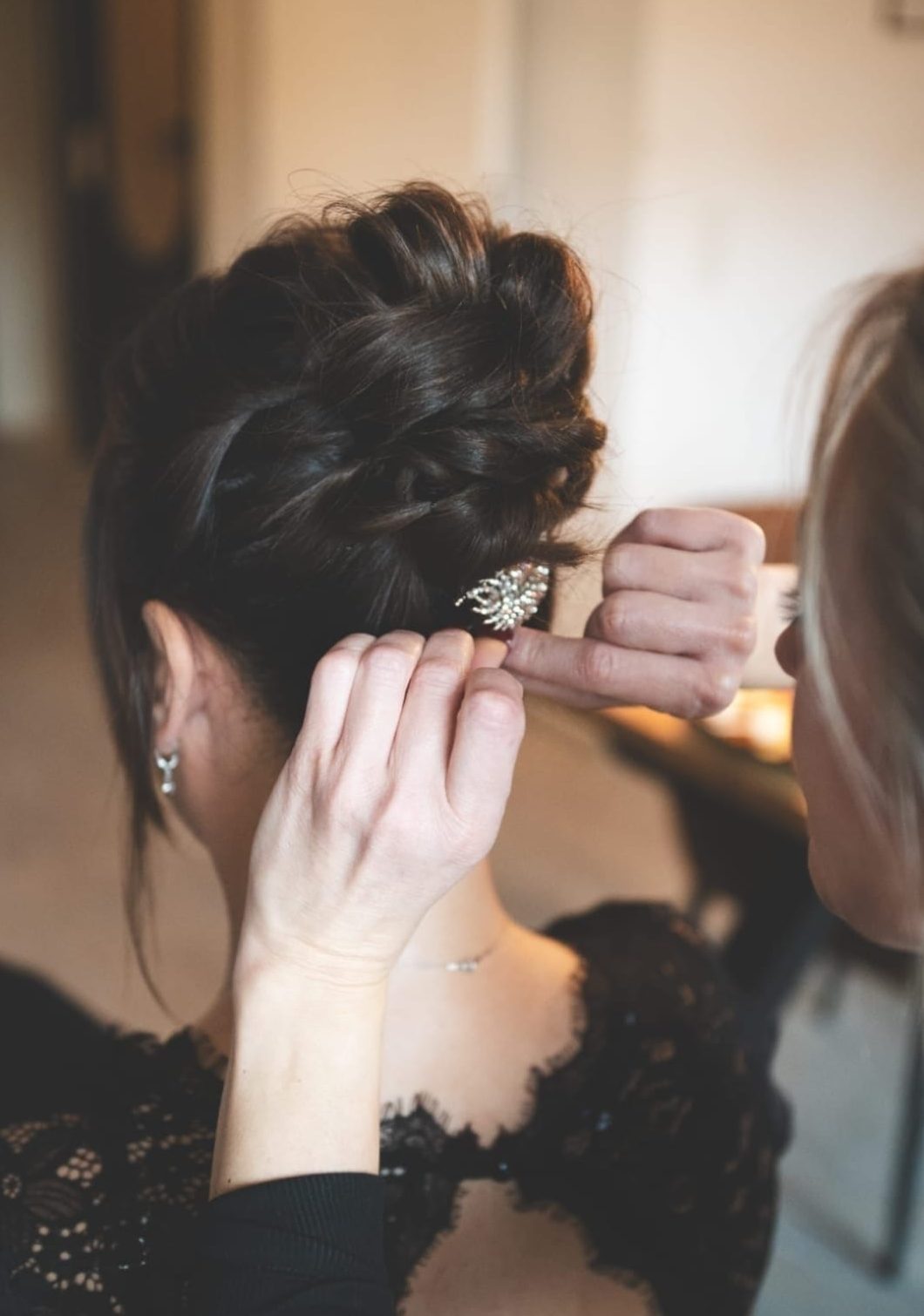 Nahaufnahme einer eleganten, gesteckten Brautfrisur mit floralem Haarschmuck, gestylt am von mobiler Stylistin Veronika Raimkulow